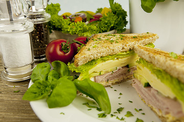 Image showing fresh tasty club sandwich with cheese and ham on table
