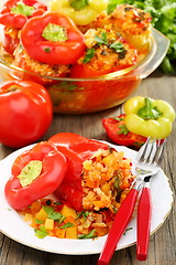 Image showing Sweet peppers stuffed with vegetables on a wooden table.