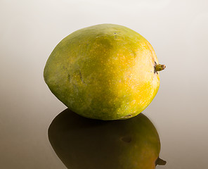 Image showing Green mango on mirror like surface