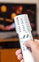 Image showing Close up of TV remote control with television