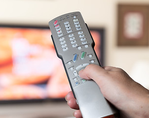 Image showing Close up of TV remote control with television