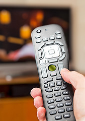 Image showing Close up of TV remote control with television