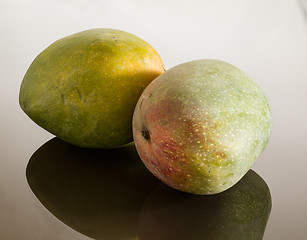 Image showing Two mangoes on reflecting surface