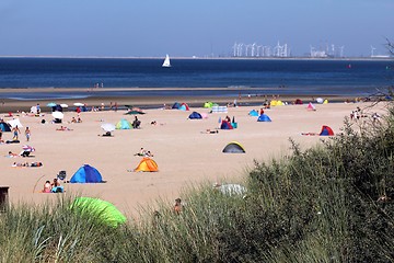 Image showing people relaxing on the beach behind reed 