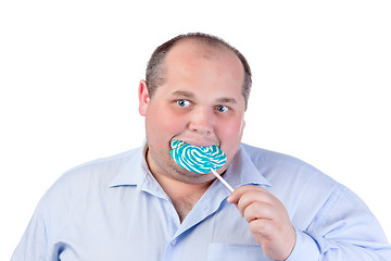 Image showing Fat Man in a Blue Shirt, Eating a Lollipop