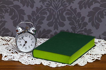 Image showing Retro alarm clock and green book