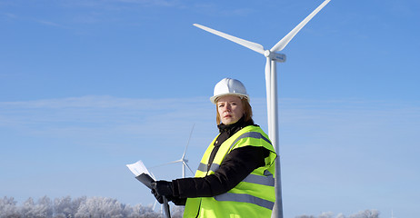 Image showing engineer or architect with white safety hat and wind turbines on