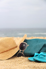 Image showing  Blue beach bag on the seacoast and straw hat 