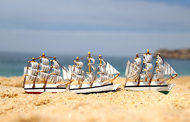 Image showing Funny small toy sailing ships on the beach 