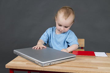 Image showing baby with laptop computer in grey background
