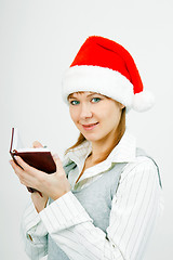Image showing girl with a notebook in santa hat