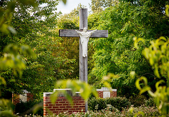 Image showing Statue of Jesus on cross in wooded garden