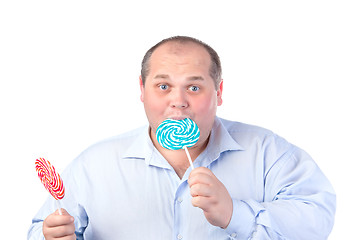 Image showing Fat Man in a Blue Shirt, Eating a Lollipop