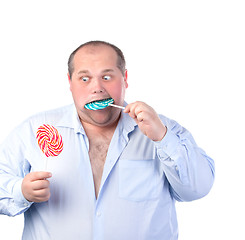 Image showing Fat Man in a Blue Shirt, Eating a Lollipop