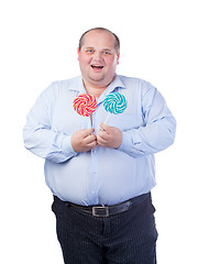 Image showing Fat Man in a Blue Shirt, Eating a Lollipop