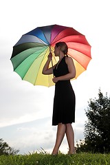 Image showing Woman with rainbow umbrella on a hill