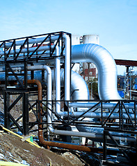 Image showing industrial pipelines with insulation against natural blue backgr