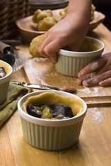 Image showing Detail of child hands making plum tart