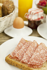 Image showing tasty breakfast with salami toast on table