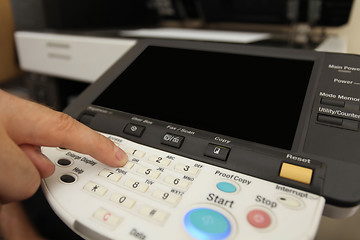 Image showing Finger pressing of keyboard buttons of the laser copier