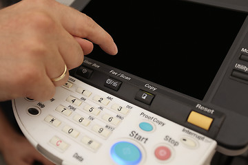 Image showing Finger pressing of keyboard buttons of the laser copier