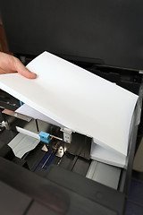 Image showing details of hand inserts a paper A4 into a laser copier