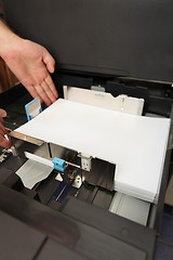 Image showing details of hand inserts a paper A4 into a laser copier