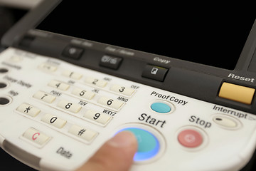 Image showing Finger pressing of keyboard buttons of the laser copier