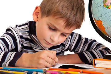 Image showing Cute schoolboy is writting