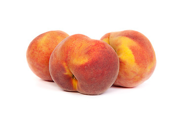 Image showing Three tasty juicy peaches on a white background