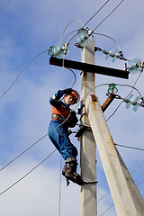 Image showing Electrician connects wires on a pole
