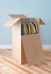 Image showing Wardrobe box with colorful clothing, ready for moving