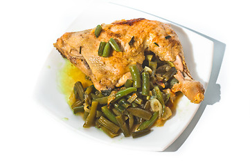 Image showing Fried chicken leg with french beans on white plate.