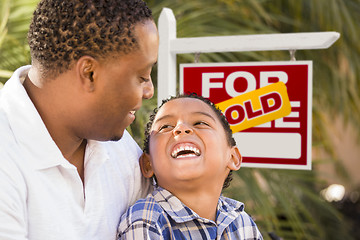 Image showing Mixed Race Father and Son In Front of Sold Real Estate Sign