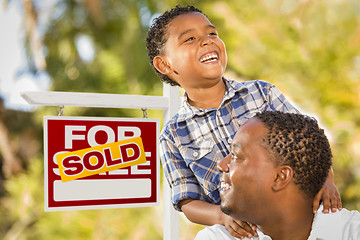 Image showing Mixed Race Father and Son In Front of Sold Real Estate Sign