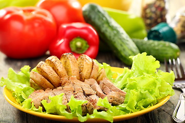 Image showing Meat and potatoes on a green salad.