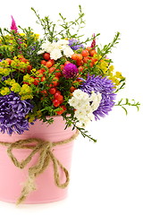 Image showing Bouquet of flowers and fruit in pink bucket.