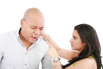 Image showing Beautiful Caucasian woman twisting boyfriend's ear while he scre