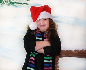 Image showing Cute girl in snow wearing Santa hat