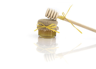 Image showing Wooden honey drizzlier and a jar of honey