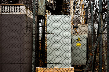 Image showing Electric boxes behind fence