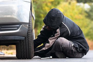 Image showing Young man repairing car outdoors