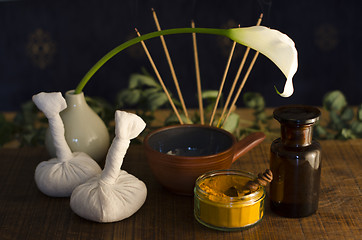 Image showing An arrangement of , spice, oil and massaging tools used in Ayurv