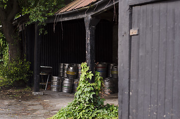 Image showing A cache of metal beer barrels in a pub porch