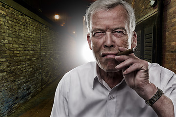 Image showing Senior man smoking a cigar