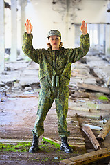 Image showing The woman in military uniform surrenders