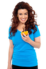 Image showing Fit girl drinking fresh orange juice directly from fruit