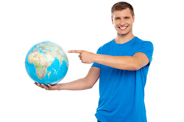 Image showing Handsome young caucasian pointing at globe