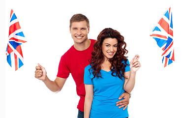 Image showing Young love couple embracing and holding national flag