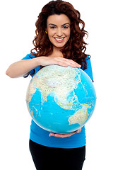 Image showing Cheerful girl holding globe safely with both hands